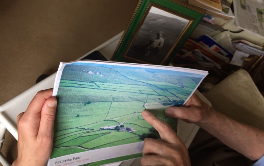 Someone showing and pointing at a photo of Fairbanks farm
